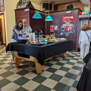 people standing around a table with food on it