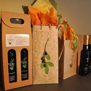 three bottles of olive oil and a gift bag