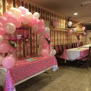 a pink and white balloon arch