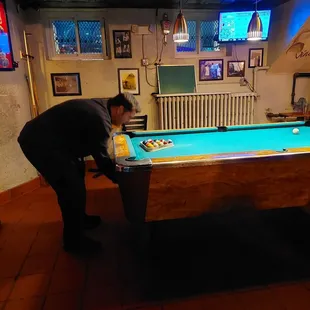 a man leaning over a pool table