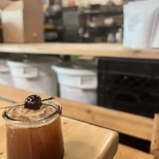 a cup of coffee with a cherry on top