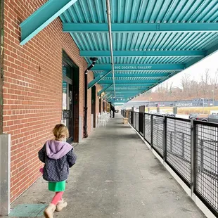 a little girl walking down a walkway