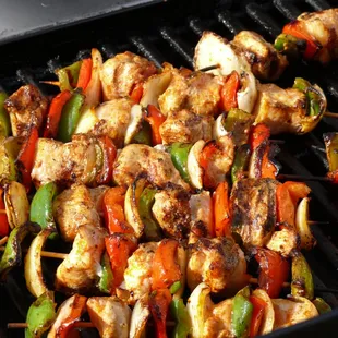skewers of meat and vegetables on a grill