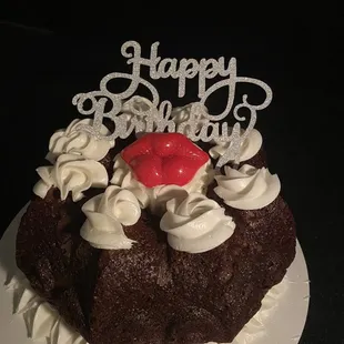 a chocolate cake with whipped cream and a cherry on top