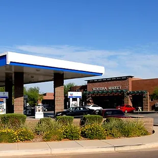 a gas station with cars parked in front of it