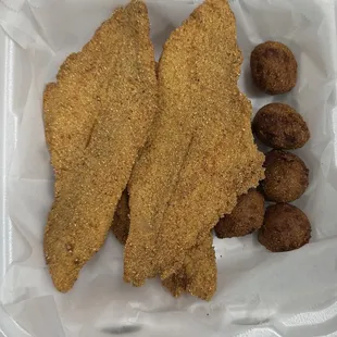 two fried fish fillets and some nuts