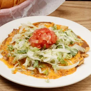 Frito pie with fresh vegetables on top.