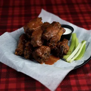 a plate of wings with dipping sauce and apple slices