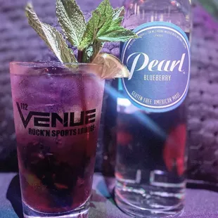 a purple cocktail with a mint leaf garnish