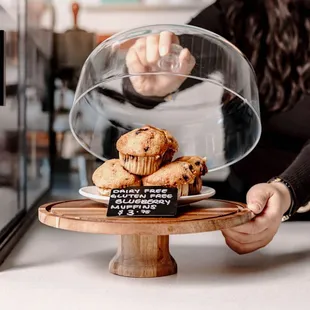 a woman placing a muffin on a plate