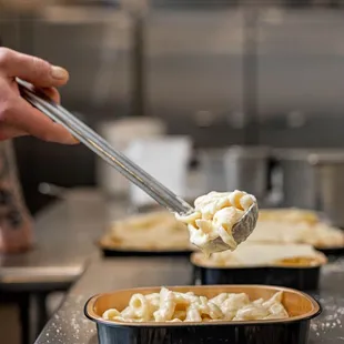 a person serving macaroni and cheese