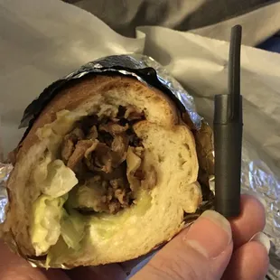 12” Cheesesteak sub, sliced in half by chef and unaltered. Less than a normal sized pen cap in size, with quarter sized meat/topping inside.