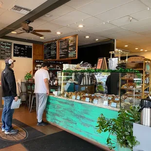 a man and a woman standing in front of a coffee shop