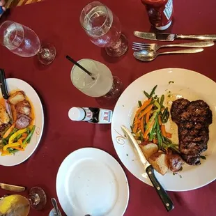 a man sitting at a table with plates of food