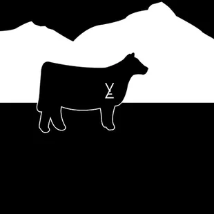 a cow in front of a mountain