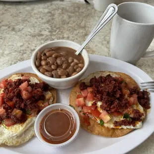 Huevos rancheros with spicy sauce, frijoles, and a cup of joe.