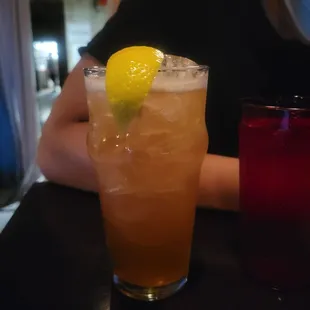 a glass of iced tea with a lemon wedge