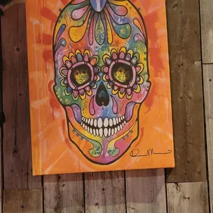 a painting of a sugar skull on a wooden deck