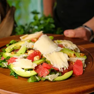 a person holding a plate of salad