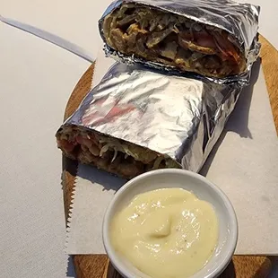 a burrito and a bowl of sauce