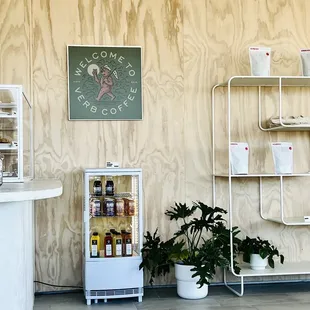 a small refrigerator and shelves in a coffee shop