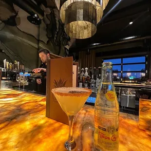 a martini and a bottle on a bar