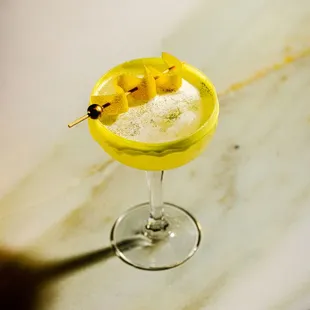 a yellow cocktail with pineapple garnish