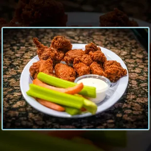 a plate of chicken nuggies and celery sticks