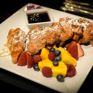 a plate of french toast with fruit