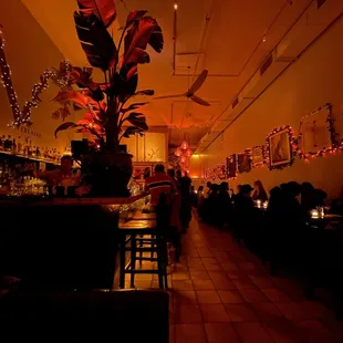 a dimly lit restaurant with people sitting at tables