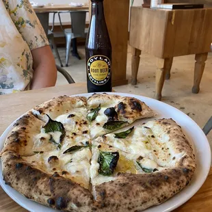 a person sitting at a table with a bottle of beer