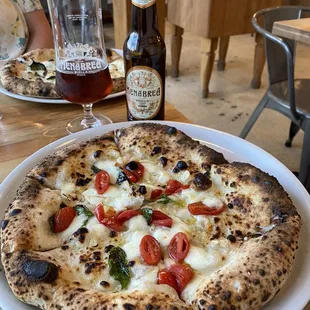 a plate of pizza and a bottle of beer