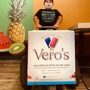 a boy with a cart full of fruit
