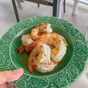 a person holding a plate of shrimp