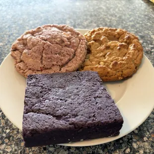 A selection of baked goods, including peanut butter miso and strawberry cookies and an ube brownie