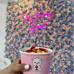 Pineapple frozen yogurt topped with chamoy, tajin, and gummy peach rings