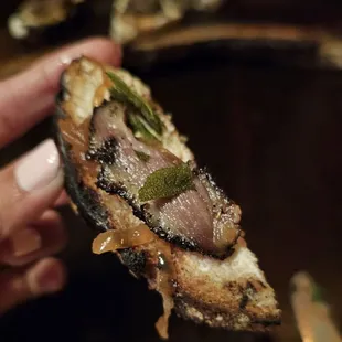 a hand holding a piece of bread