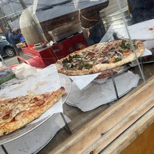 a variety of pizzas in a display case