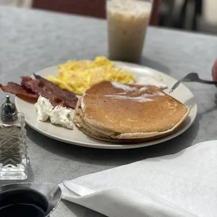 Chai pancakes with scrambled eggs and bacon, with an iced chai.
