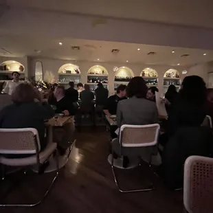 a group of people sitting at tables in a restaurant