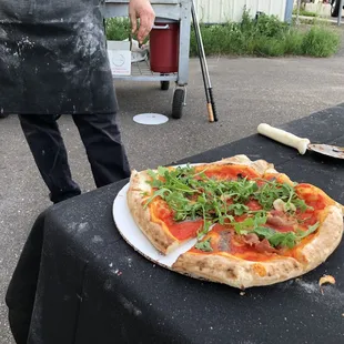 Finished pizza, prosciutto, anchovy, tomato sauce, garlic, olive oil and arugula. Tastes even better then it looks!