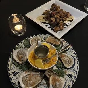 a plate of oysters and a bowl of sauce