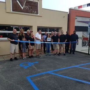 a group of people cutting a ribbon
