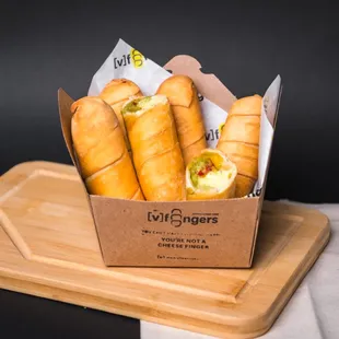 a box of french bread rolls on a cutting board