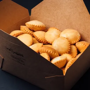 a cardboard box filled with a variety of pastries