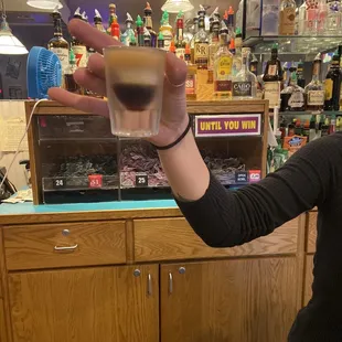 a woman holding a shot of liquor