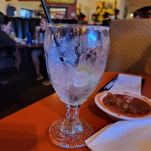 a glass of ice and a bowl of chili