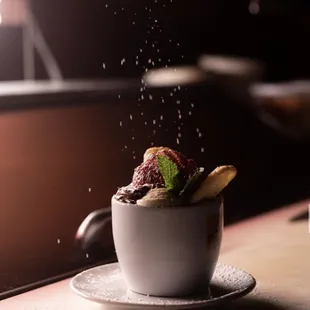 a cup of ice cream with strawberries and chocolate
