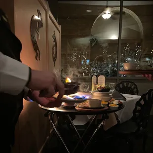 a person lighting a candle on a plate