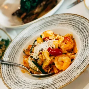 a plate of pasta with shrimp and spinach